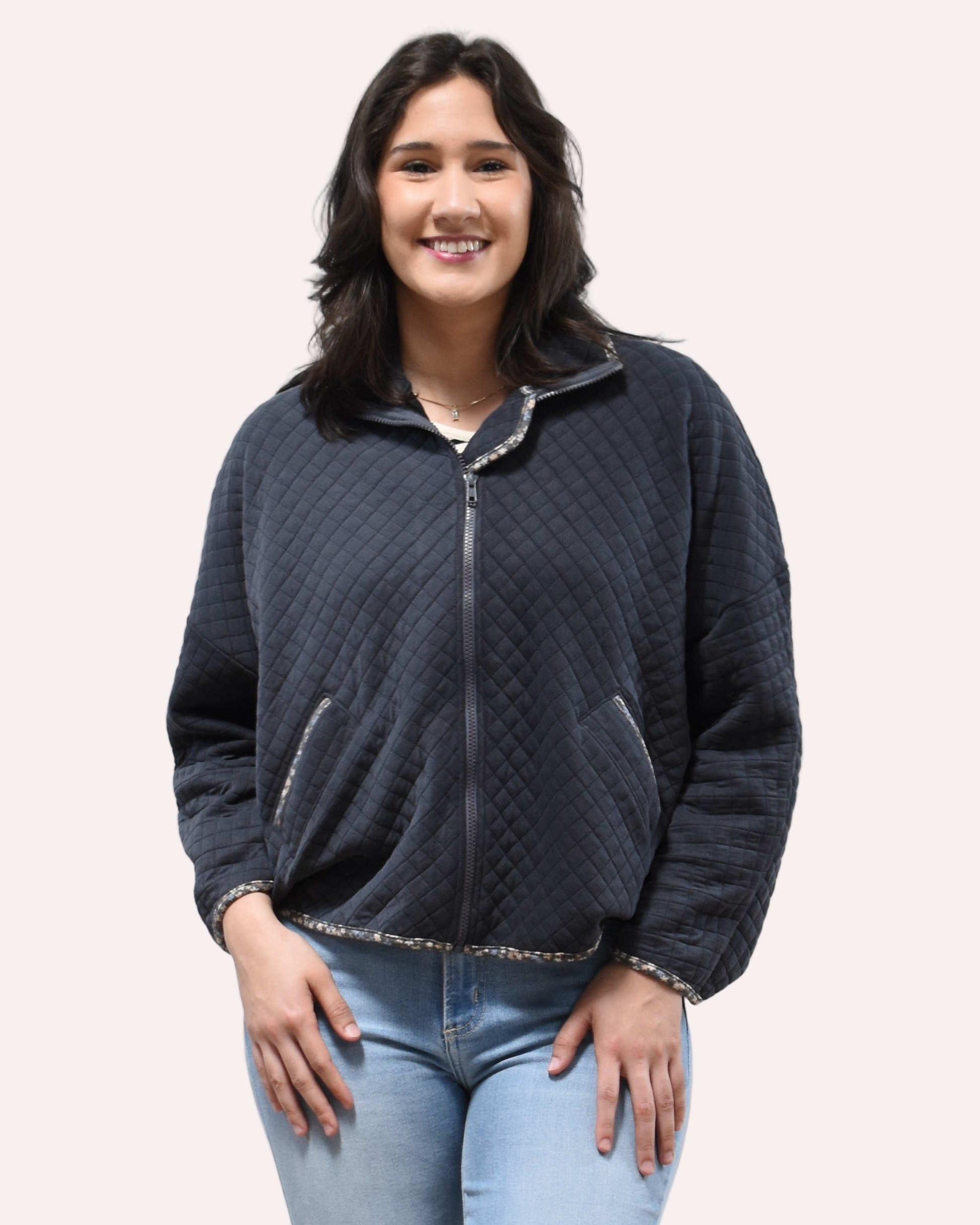 Front view of the quilted floral contrast zip-up jacket showing the mock neck, side pockets, and feminine detailing.