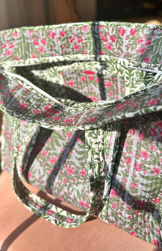 Quilted Garden Tote with boho floral pattern in moss green, pink, and blue, handcrafted from quilted cotton with zipper closure and interior pocket, ethically made in India by fair-trade artisans.