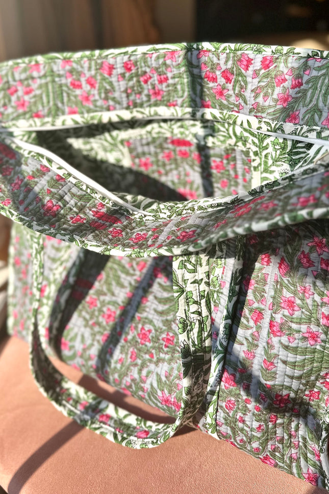 Quilted Garden Tote with boho floral pattern in moss green, pink, and blue, handcrafted from quilted cotton with zipper closure and interior pocket, ethically made in India by fair-trade artisans.