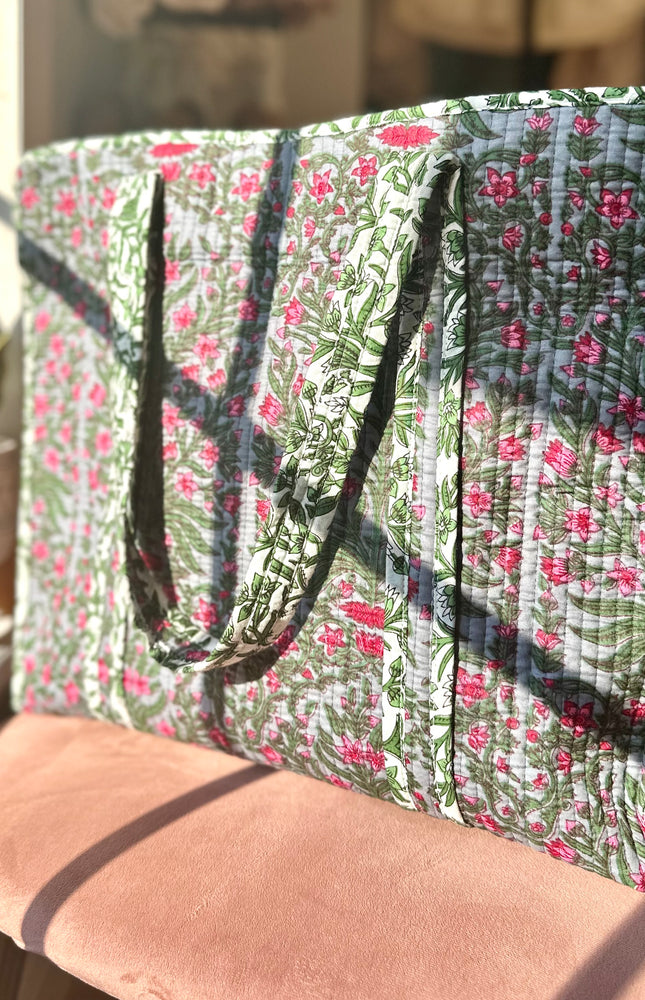 Quilted Garden Tote with boho floral pattern in moss green, pink, and blue, handcrafted from quilted cotton with zipper closure and interior pocket, ethically made in India by fair-trade artisans.