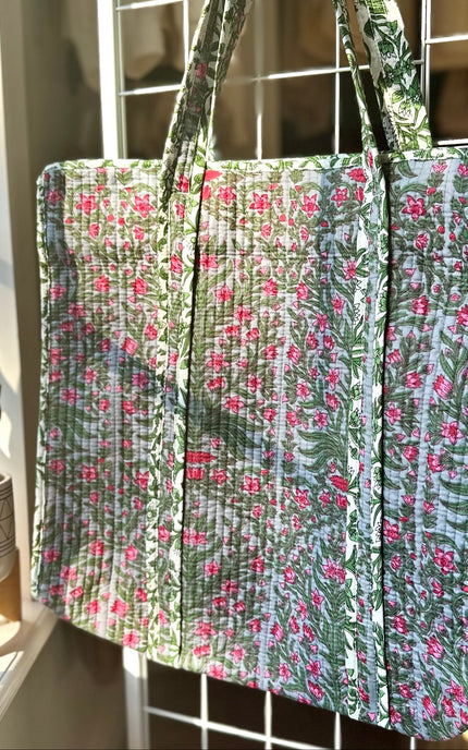 Quilted Garden Tote with boho floral pattern in moss green, pink, and blue, handcrafted from quilted cotton with zipper closure and interior pocket, ethically made in India by fair-trade artisans.