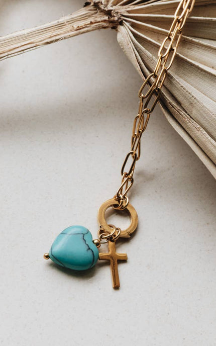 Radiant Heart Necklace — turquoise heart pendant with 14K gold-plated cross charm on waterproof chain from Justyna Grace Boutique.