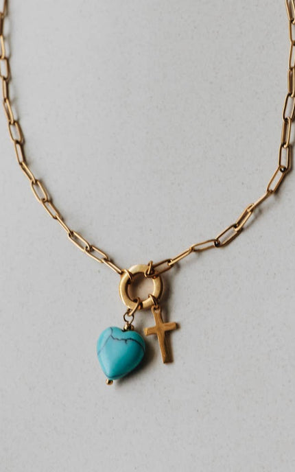 Radiant Heart Necklace — turquoise heart pendant with 14K gold-plated cross charm on waterproof chain from Justyna Grace Boutique.