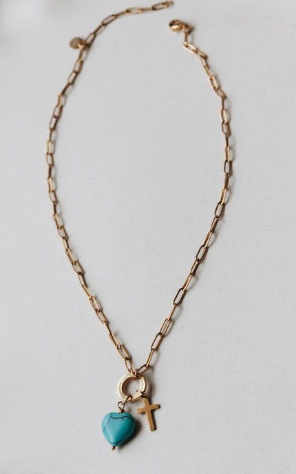 Radiant Heart Necklace — turquoise heart pendant with 14K gold-plated cross charm on waterproof chain from Justyna Grace Boutique.