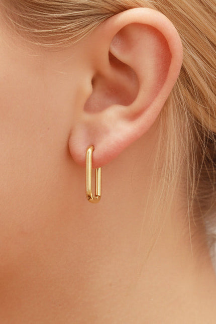 Rectangular hoop earrings worn on ear, showing how sleek huggie style sits