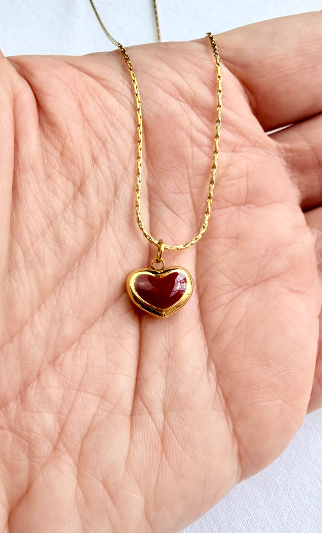Close-up of red heart pendant showing vibrant color against 18K gold PVD finish