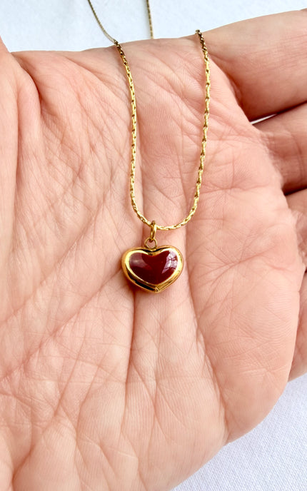 Close-up of red heart pendant showing vibrant color against 18K gold PVD finish