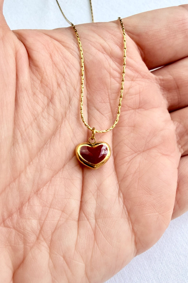 Close-up of red heart pendant showing vibrant color against 18K gold PVD finish