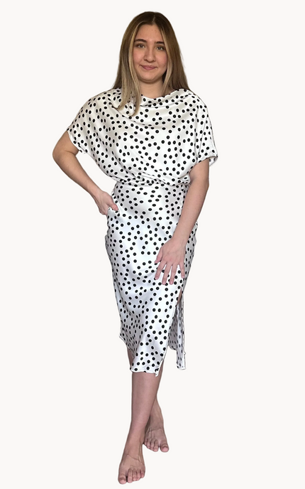 Woman wearing a white dress with black polka dots on a white background