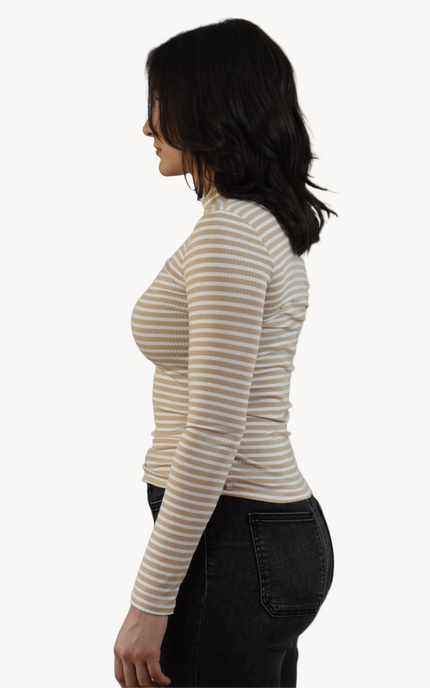 Woman wearing a striped long-sleeve top and dark pants on a white background