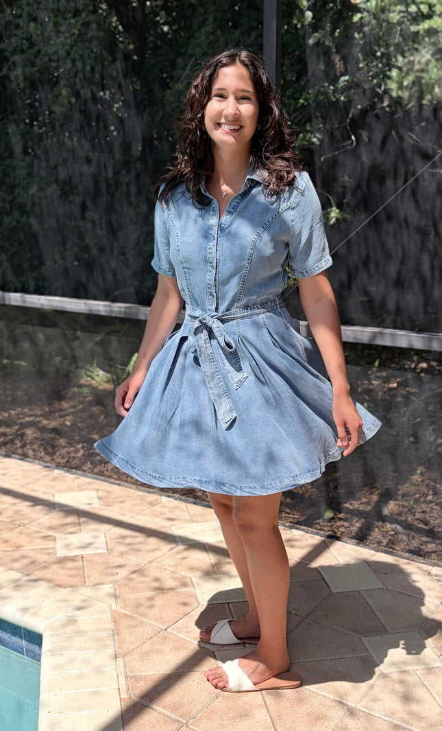 Woman wearing light-wash Tencel shirt dress in soft neutral tone, styled for everyday wear