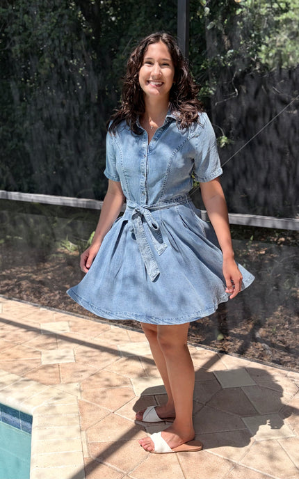 Woman wearing light-wash Tencel shirt dress in soft neutral tone, styled for everyday wear