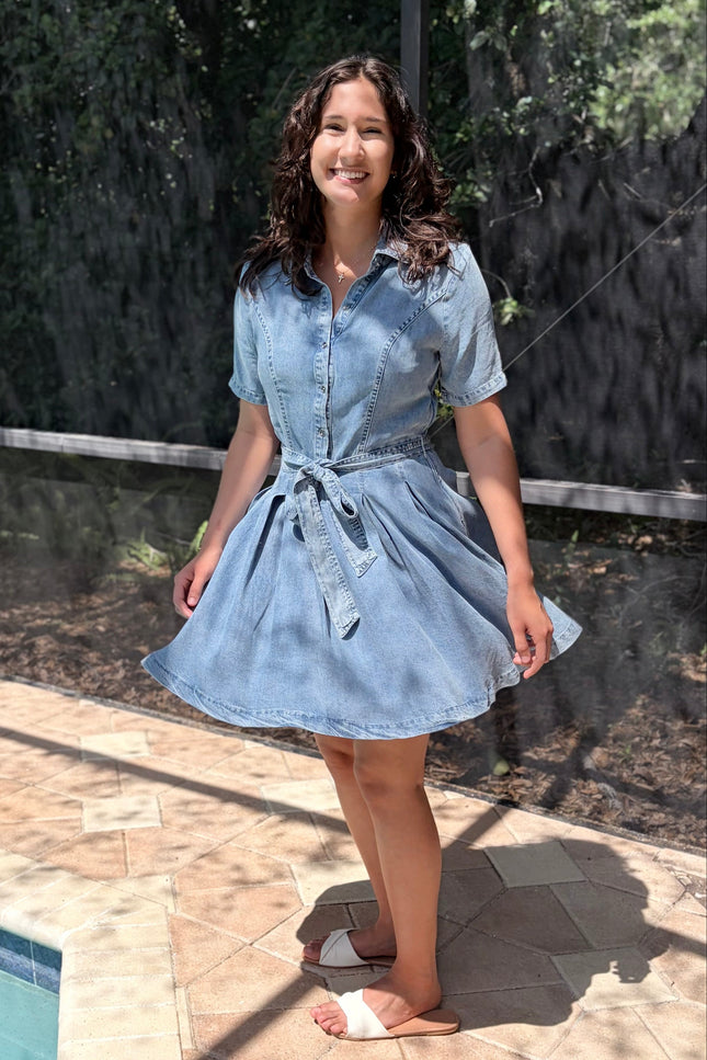 Woman wearing light-wash Tencel shirt dress in soft neutral tone, styled for everyday wear