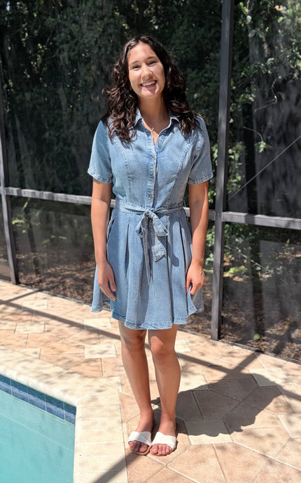 Woman wearing light-wash Tencel shirt dress in soft neutral tone, styled for everyday wear