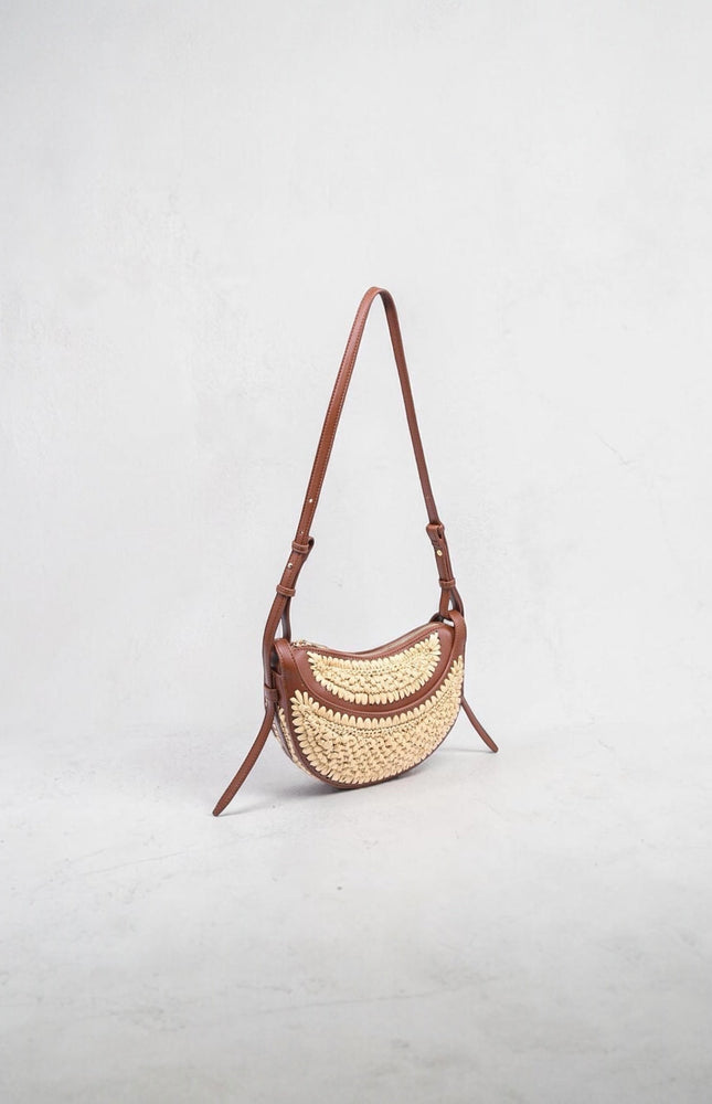 Modern crescent-shaped crossbody bag featuring sculpted silhouette and textured detail