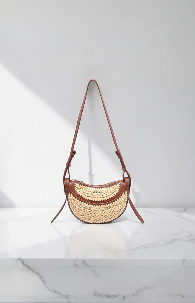 Sloane Crescent Crossbody Bag in vegan leather with woven front panel, flat lay view