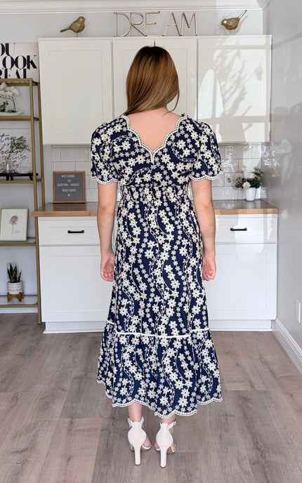 Back view of Sloane embroidered cotton floral midi dress with feminine flowy silhouette