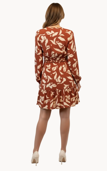 Woman wearing a rust-colored dress with floral pattern on a white background