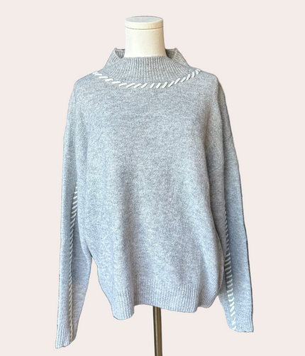 Heather grey crew-neck sweater with soft contrast stitching along the neckline and sleeves, midweight knit with stretch, photographed on a Soft Linen background for Justyna Grace Boutique.