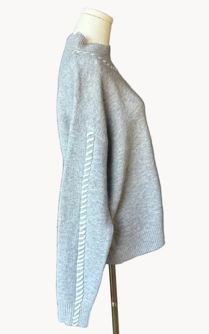 Heather grey crew-neck sweater with soft contrast stitching along the neckline and sleeves, midweight knit with stretch, photographed on a Soft Linen background for Justyna Grace Boutique.