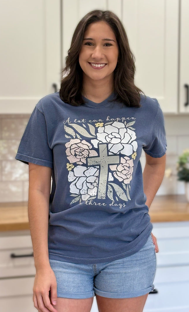 Comfort Colors “A Lot Can Happen in Three Days” Easter tee with cross and peony design, soft cotton, and relaxed unisex fit.