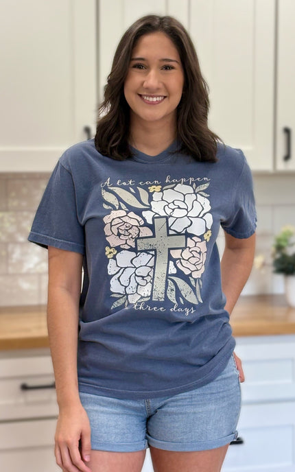 Comfort Colors “A Lot Can Happen in Three Days” Easter tee with cross and peony design, soft cotton, and relaxed unisex fit.