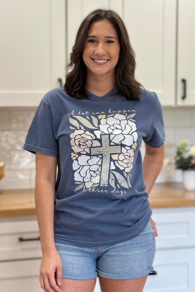 Comfort Colors “A Lot Can Happen in Three Days” Easter tee with cross and peony design, soft cotton, and relaxed unisex fit.