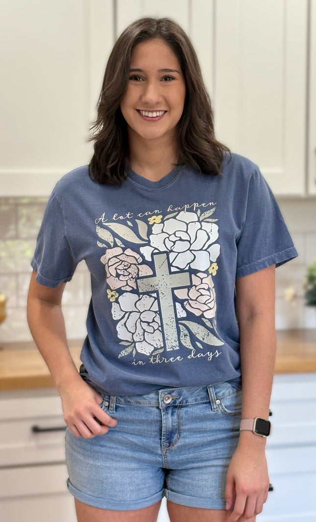 Comfort Colors “A Lot Can Happen in Three Days” Easter tee with cross and peony design, soft cotton, and relaxed unisex fit.