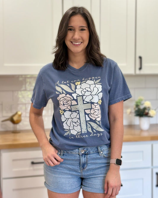Comfort Colors “A Lot Can Happen in Three Days” Easter tee with cross and peony design, soft cotton, and relaxed unisex fit.