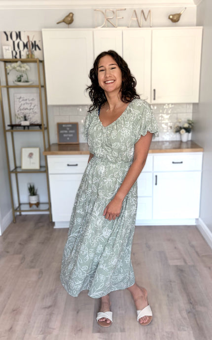 Woman wearing soft, feminine V-neck tiered midi dress styled for everyday ease