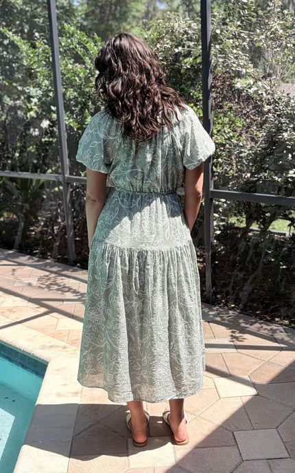 Back view of feminine tiered midi dress showing clean lines and layered skirt design