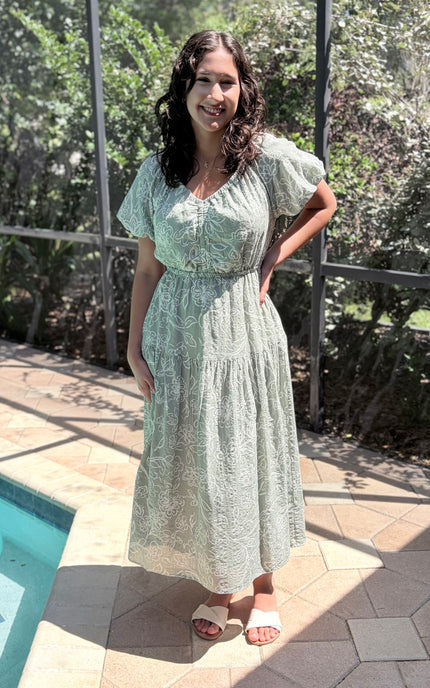 Woman wearing soft, feminine V-neck tiered midi dress styled for everyday ease