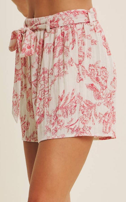 Side detail of high-rise toile-print shorts showing functional side pocket and flowy viscose blend drape
