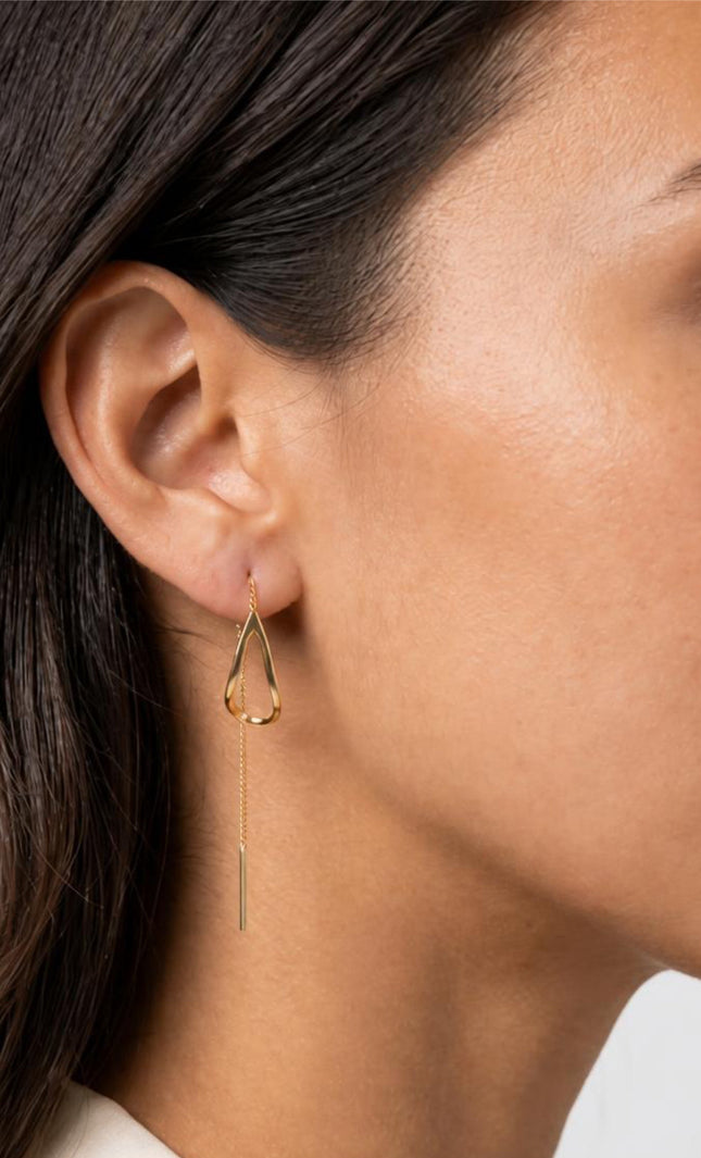 Extreme close-up side profile shot of the model's ear, highlighting the seamless, fluid drape of the 6cm thread-through chain as it loops elegantly through the piercing.