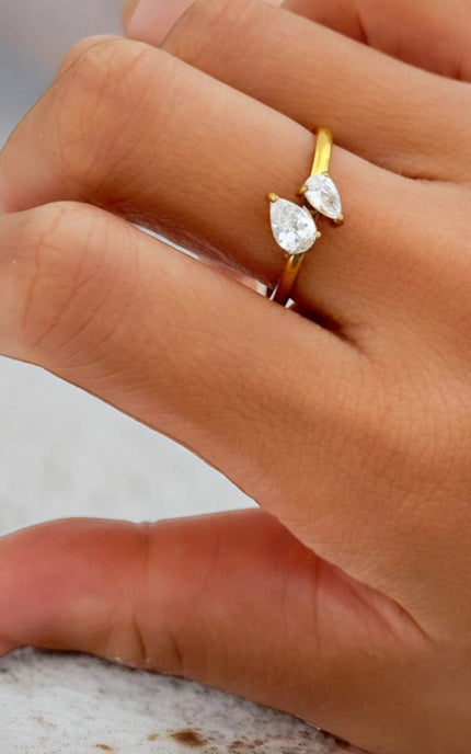 Close-up of how the two teardrop crystals sit on the slender 18K gold PVD band on finger
