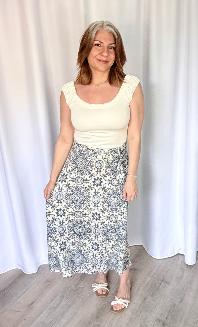 Full-length view of the Valencia Tile Midi Skirt from Justyna Grace Boutique, featuring a tile-inspired geometric print and a matching circle buckle belt.