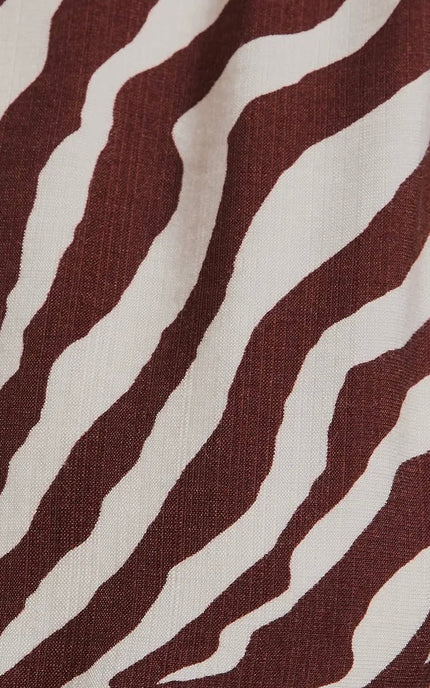 The Wild Grace Zebra Tie Dress in ivory and brown — round neckline, 3/4 sleeves, and adjustable waist tie from Justyna Grace Boutique.