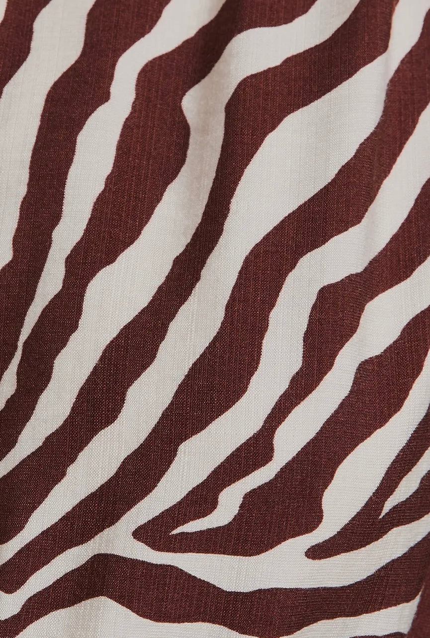 The Wild Grace Zebra Tie Dress in ivory and brown — round neckline, 3/4 sleeves, and adjustable waist tie from Justyna Grace Boutique.