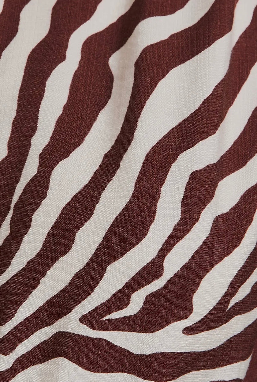 The Wild Grace Zebra Tie Dress in ivory and brown — round neckline, 3/4 sleeves, and adjustable waist tie from Justyna Grace Boutique.